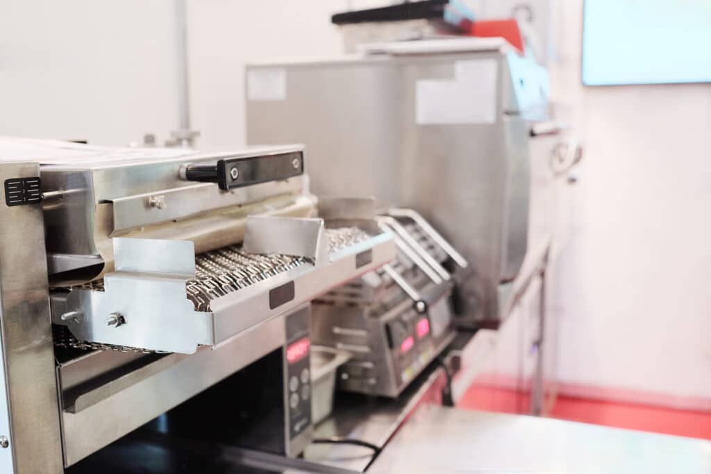 Machine industrielle en acier inoxydable avec convoyeur à mailles, réglage de niveau (1, 2, 3), et panneau de contrôle numérique.